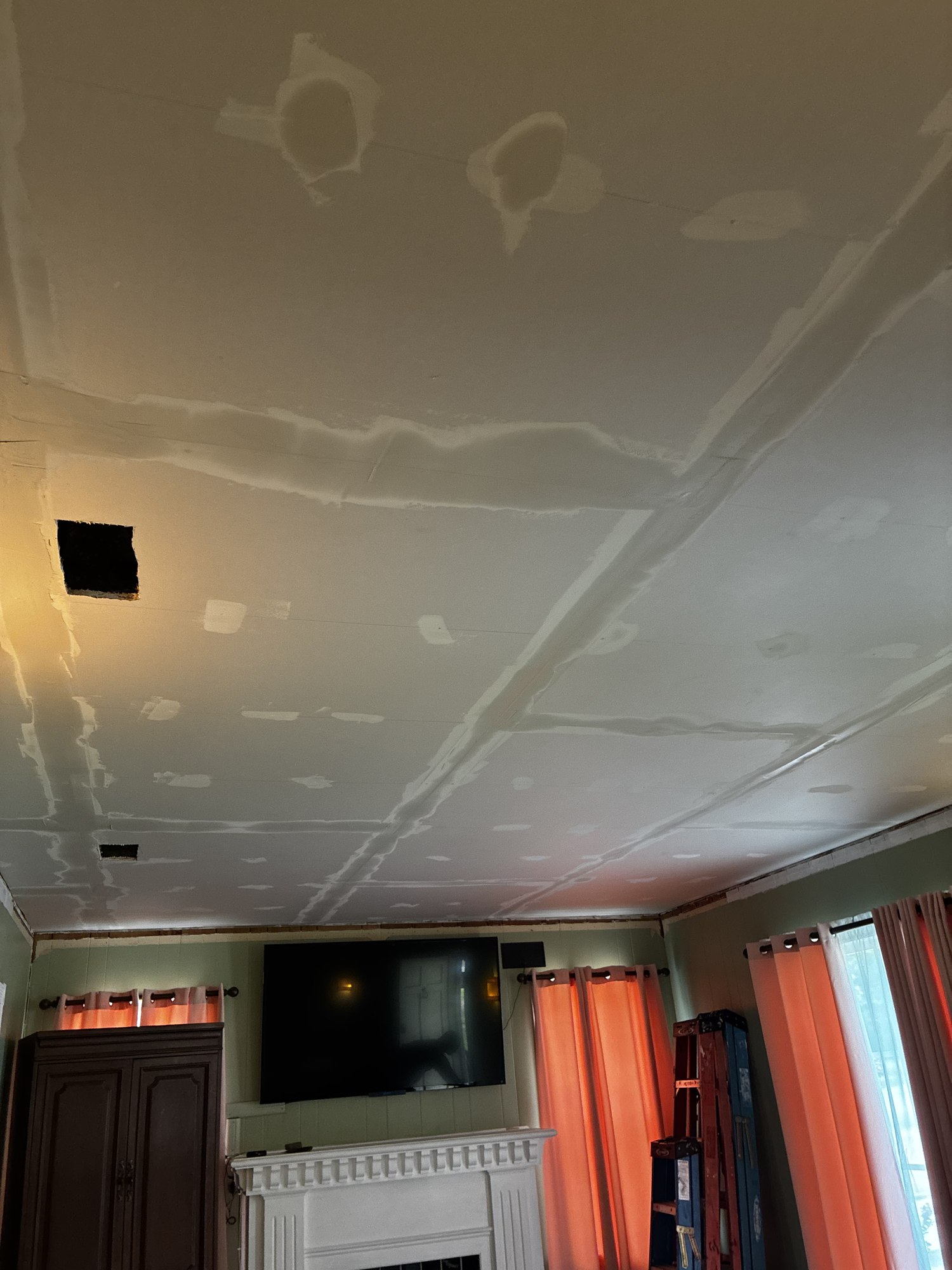 Living room ceiling with drywall seams taped and covered with joint compound.